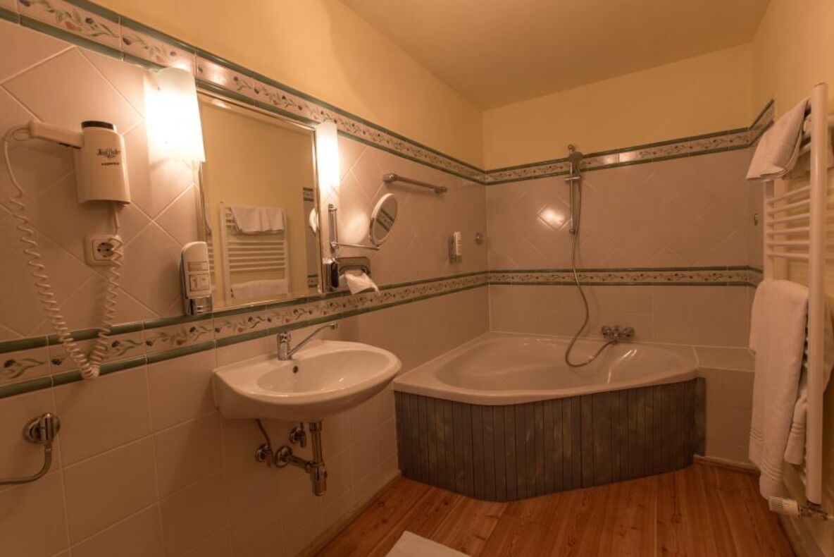 A bathroom with a sink, a bathtub, a shower, and a mirror.