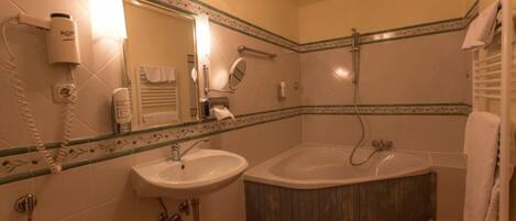 A bathroom with a sink, a bathtub, a shower, and a mirror.