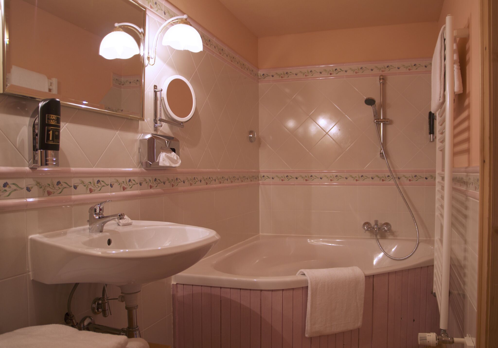 Une salle de bain avec un lavabo, un miroir et une baignoire.