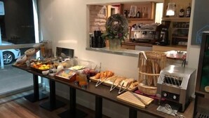 A breakfast buffet with various food items and a coffee machine. - Appart Hotel Beau Rivage (Royan)