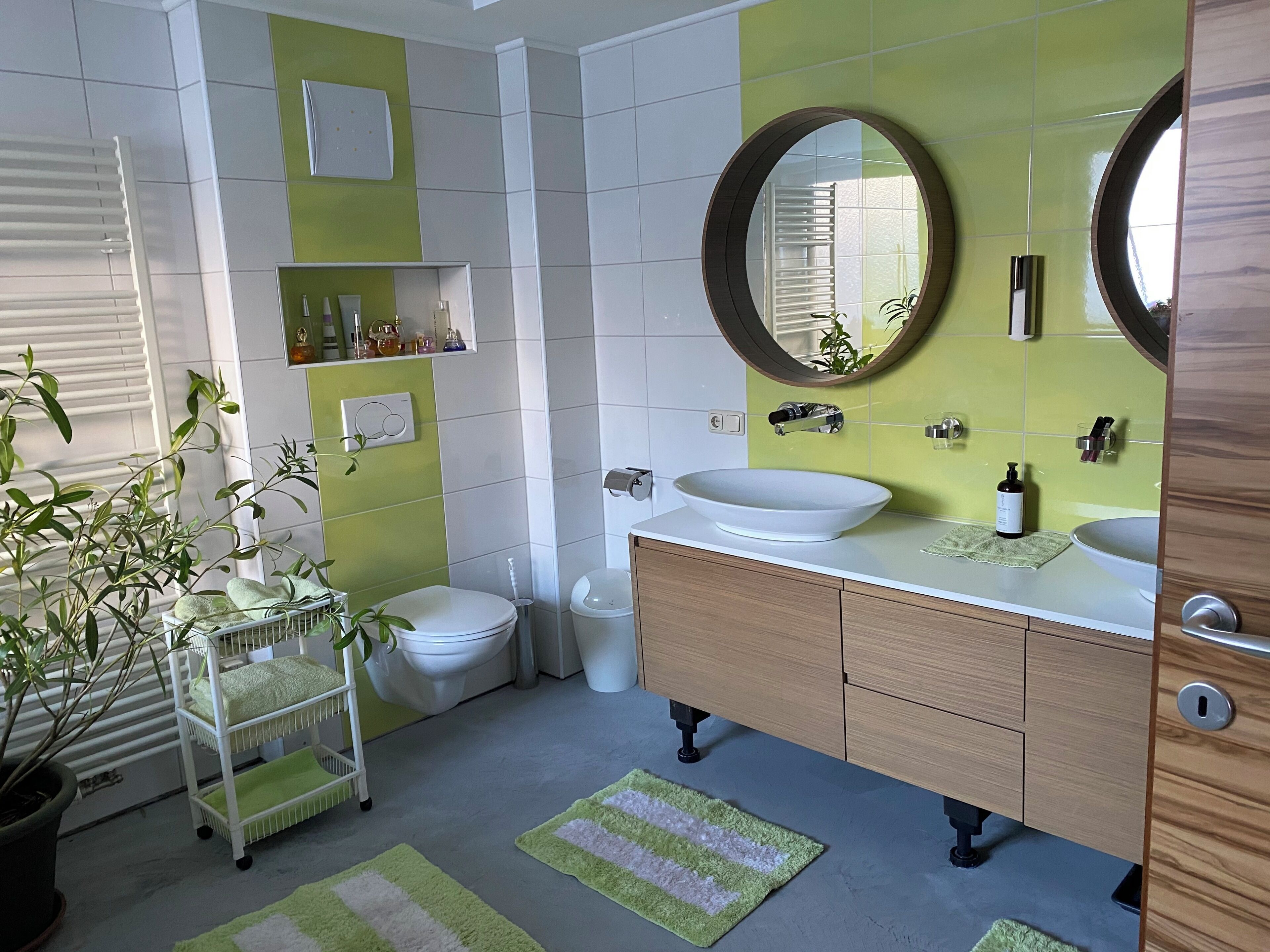 A bathroom with a white toilet, a sink with a mirror, and a shelf with toiletries.