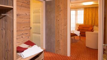 Ein Hotelzimmer mit einem Holzschrank, einem Bett mit roter und weißer Decke, einer Couch und einem gemusterten Teppich.