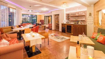 Une chambre d’hôtel moderne dotée d’un coin repas, d’une cuisine et de grandes fenêtres.