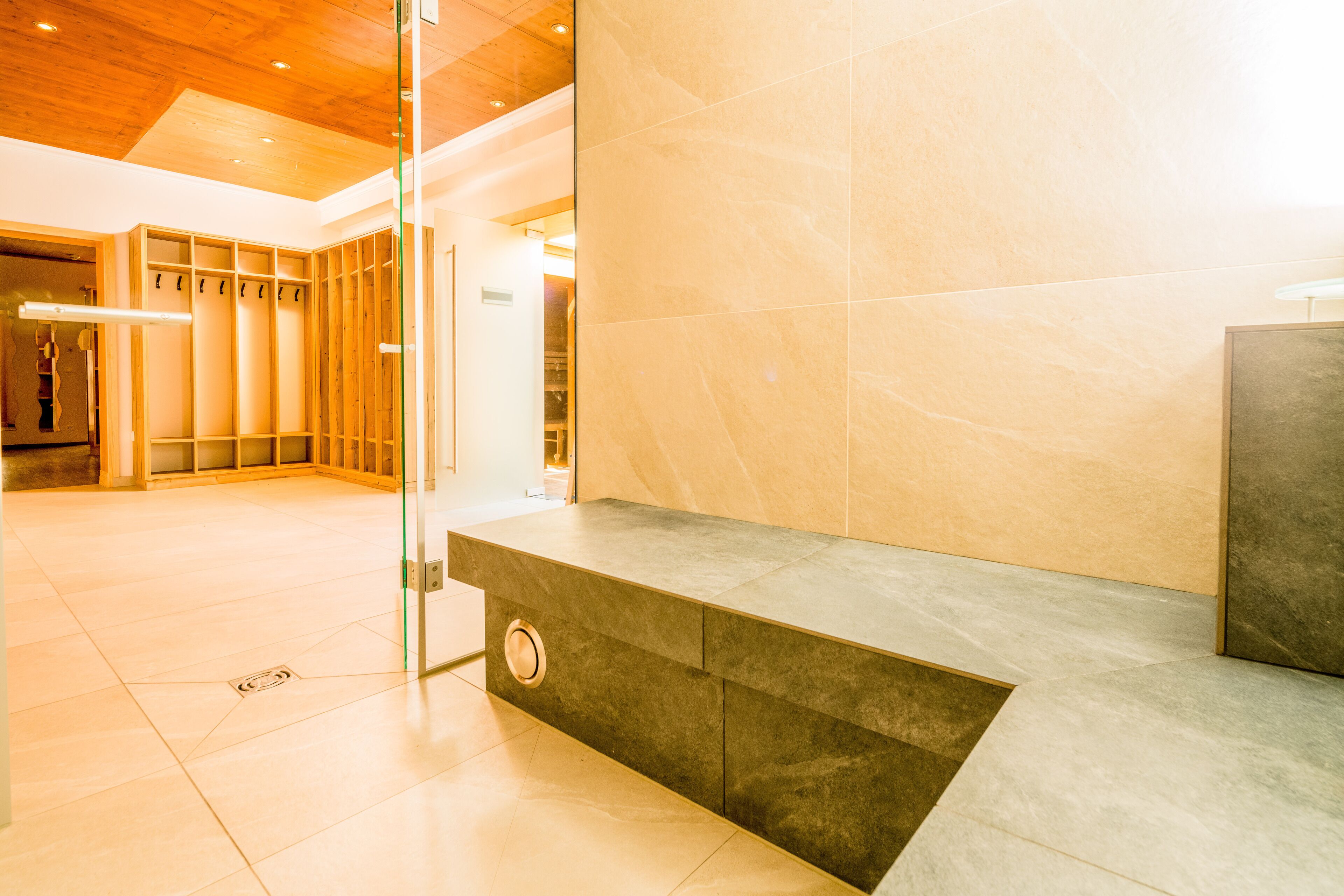 Eine moderne Lobby mit Marmorwand, einer Glastrennwand und einer Holzbodenverkleidung.