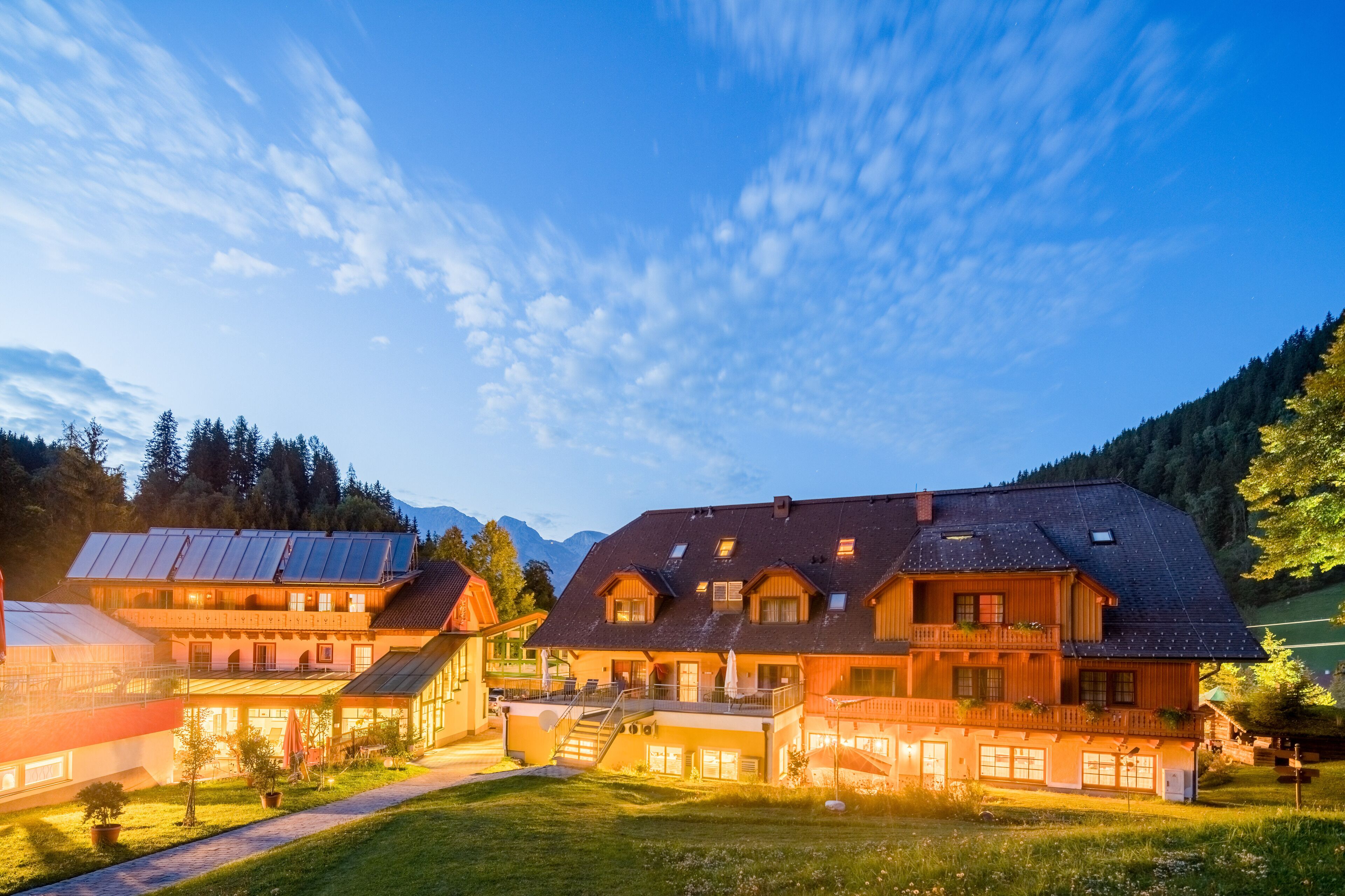 A two-story chalet with a balcony and a covered outdoor seating area.