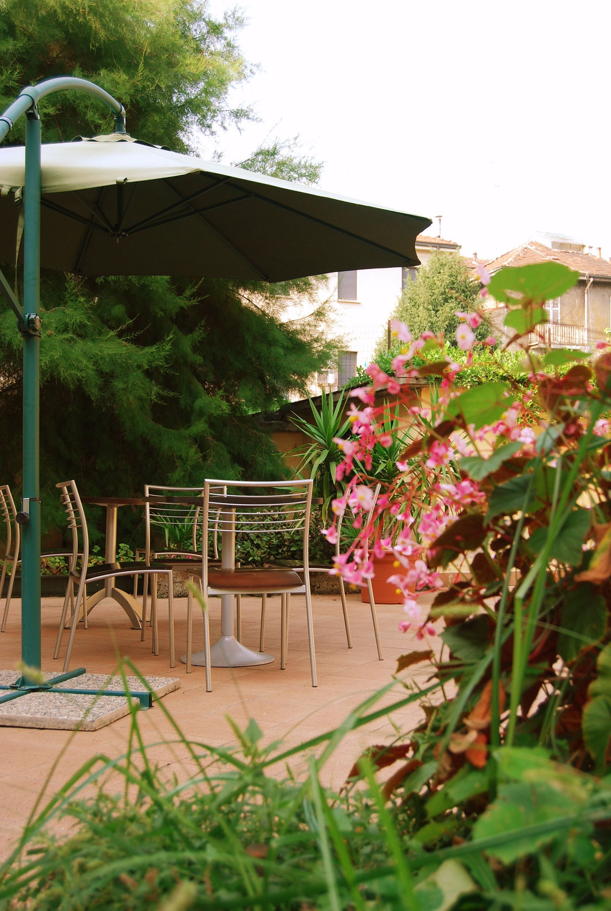 An outdoor seating area with metal chairs and a large umbrella.