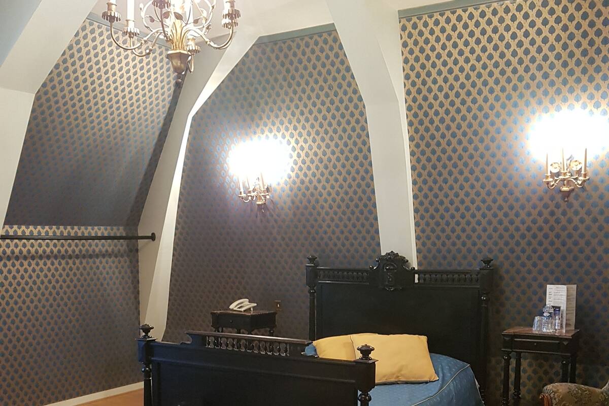 Una camera da letto con un letto a baldacchino, pavimento in legno e parete decorata.