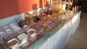A buffet with various food items and utensils.