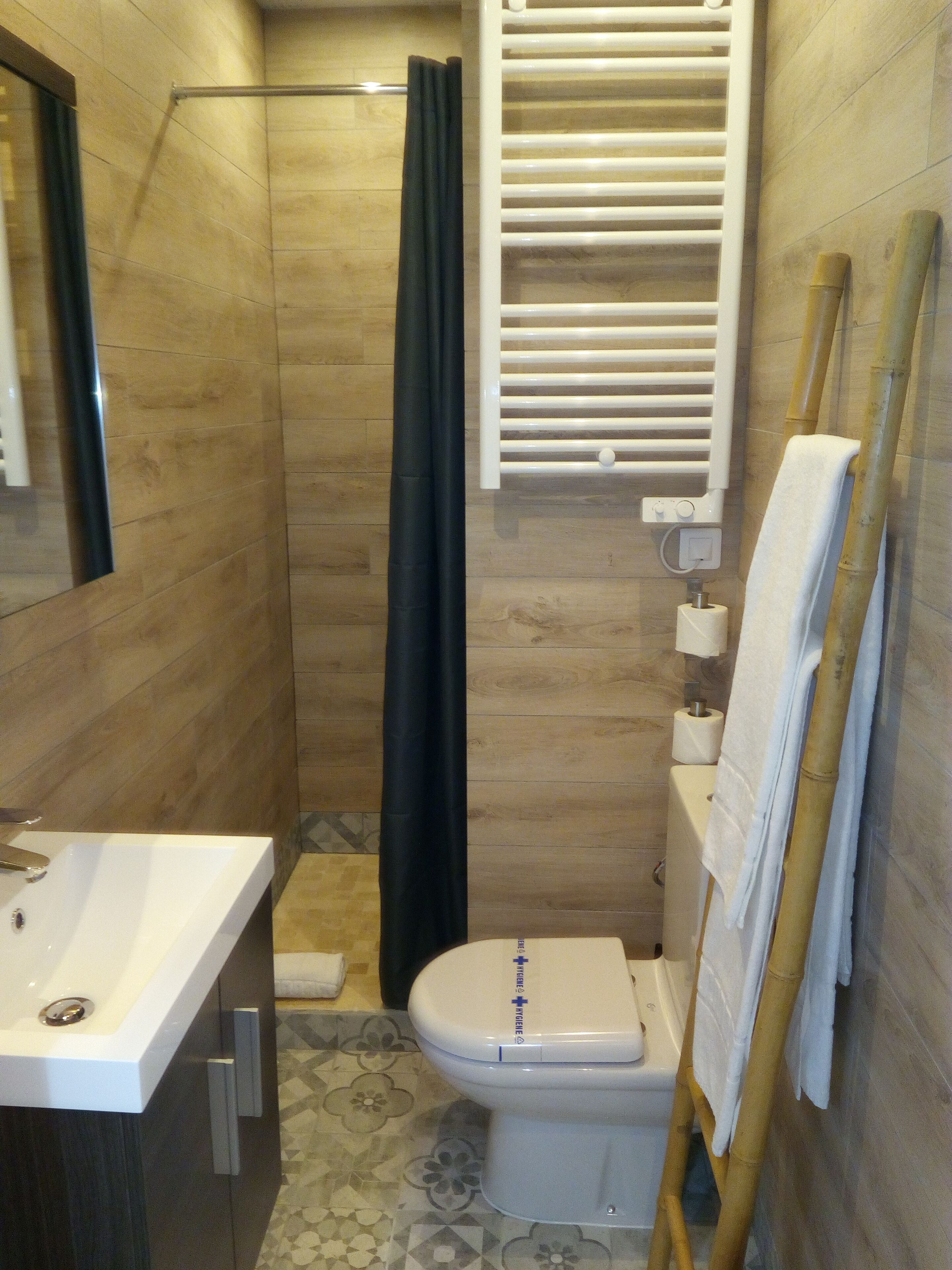 Een badkamer met een douche, toilet en wastafel.