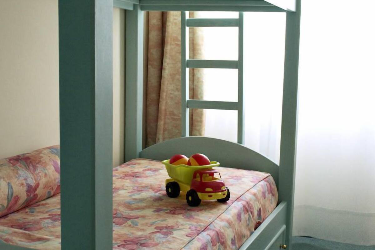Una litera con un coche de juguete en la cama inferior.