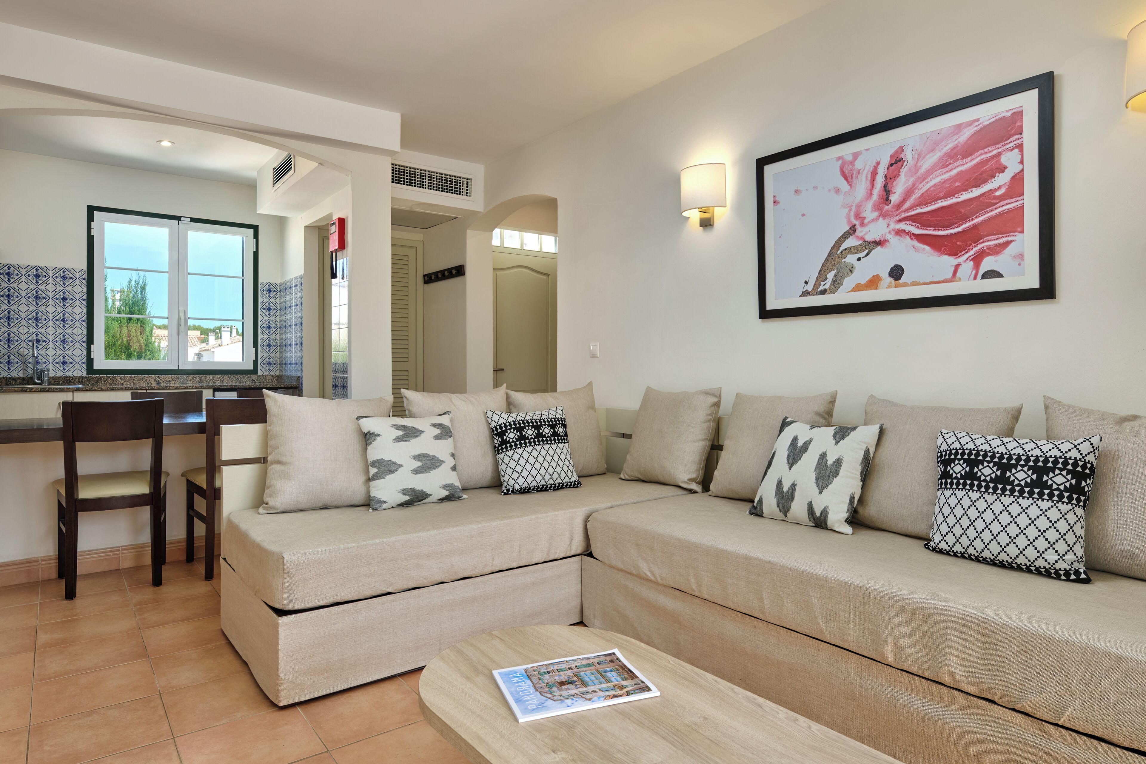 A living room with a sofa, a coffee table, and a dining area with a chair.
