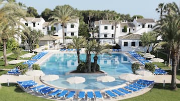 Una piscina al aire libre, sombrillas, sillones reclinables de piscina