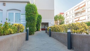 A pathway leading to a building with a reception area, a cafe, and a pool. - Hotel Bulevard (Benicassim)