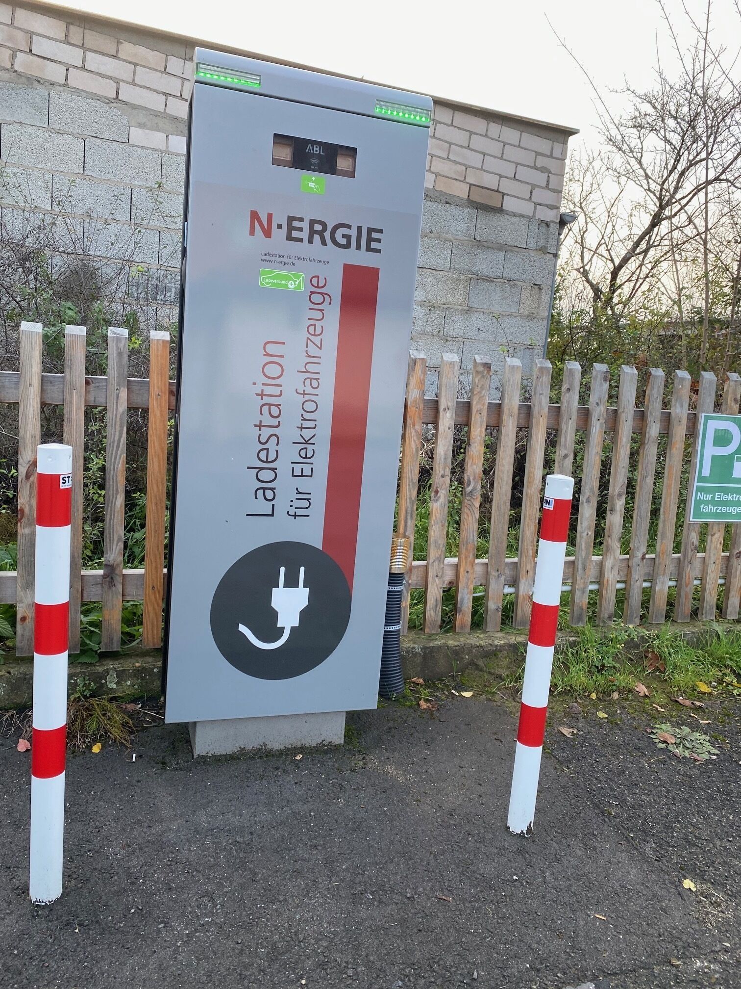Estación de carga para vehículos eléctricos con un cartel que indica que es un punto de carga público.
