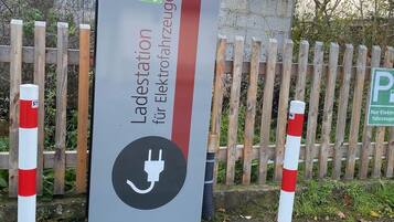 Estación de carga para vehículos eléctricos con un cartel que indica que es un punto de carga público.