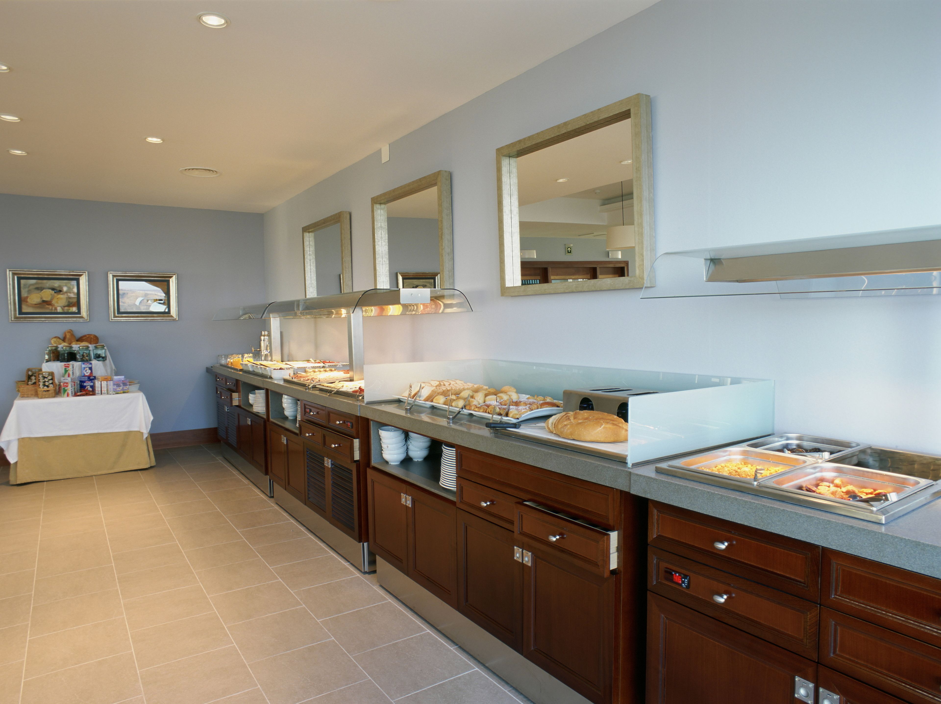 A buffet setup with various food items and a breakfast table.