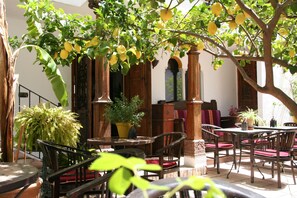 An outdoor patio with wooden furniture and a potted plant. - La Posada del Ángel (Ojén)