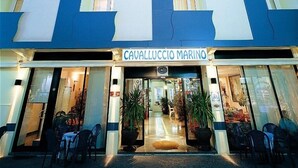 A hotel with a modern facade, featuring a prominent 'Cavalluccio Marino' sign at the entrance. - Hotel Cavalluccio Marino (Gabicce Mare)