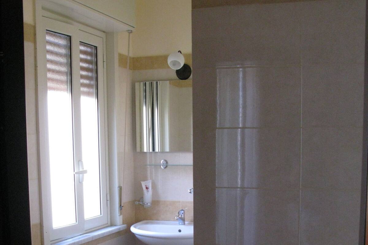 Un baño con lavamanos, espejo y ducha.