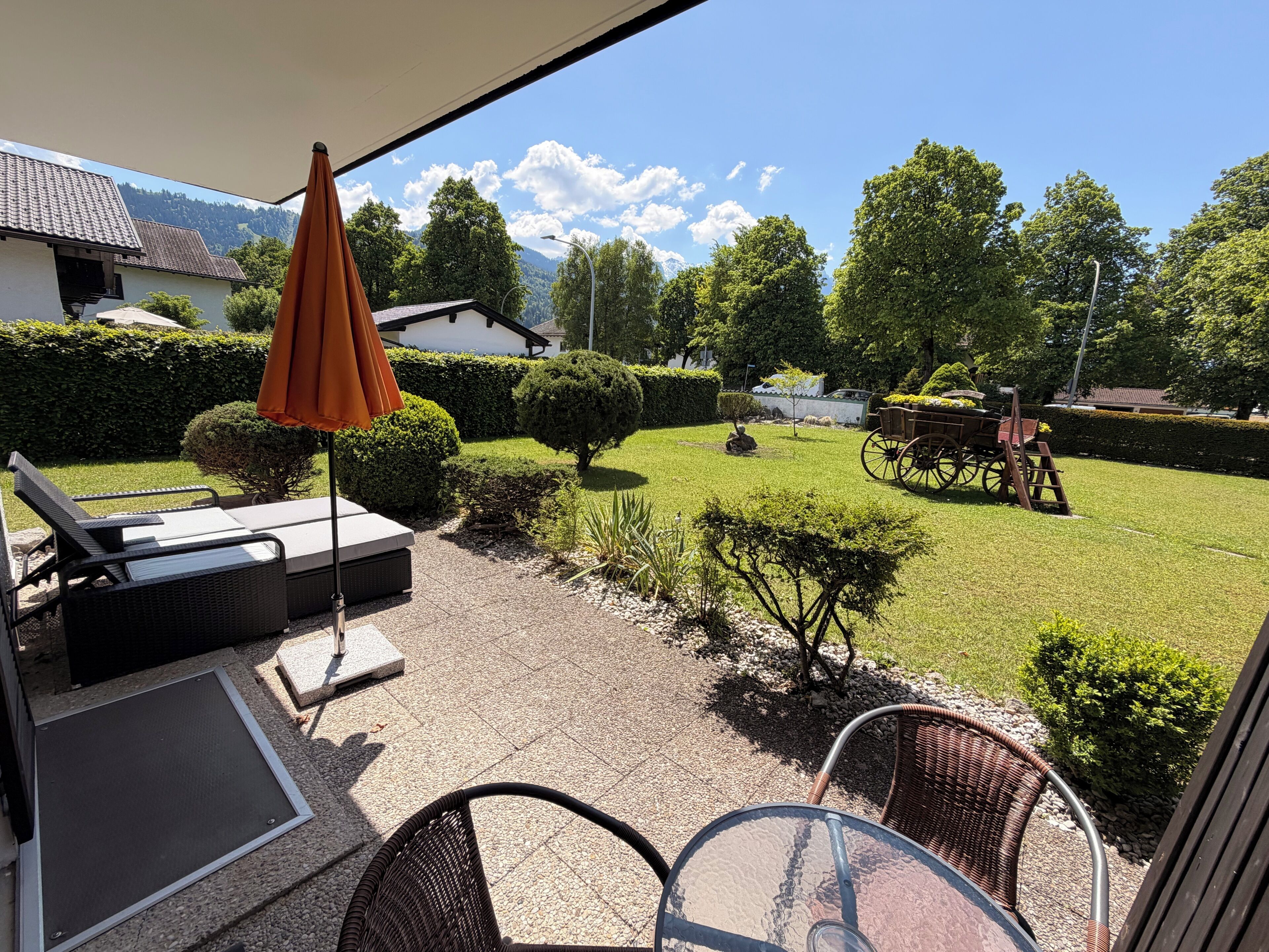 A patio with outdoor furniture, a small table, and a decorative cart.