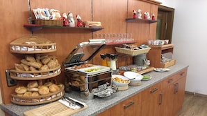 A buffet setup with various food items and utensils. - Hotel Garni Brunnthaler (Garmisch-Partenkirchen)