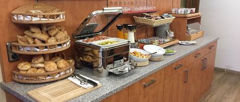 Un buffet proposant une variété de plats et d’ustensiles.