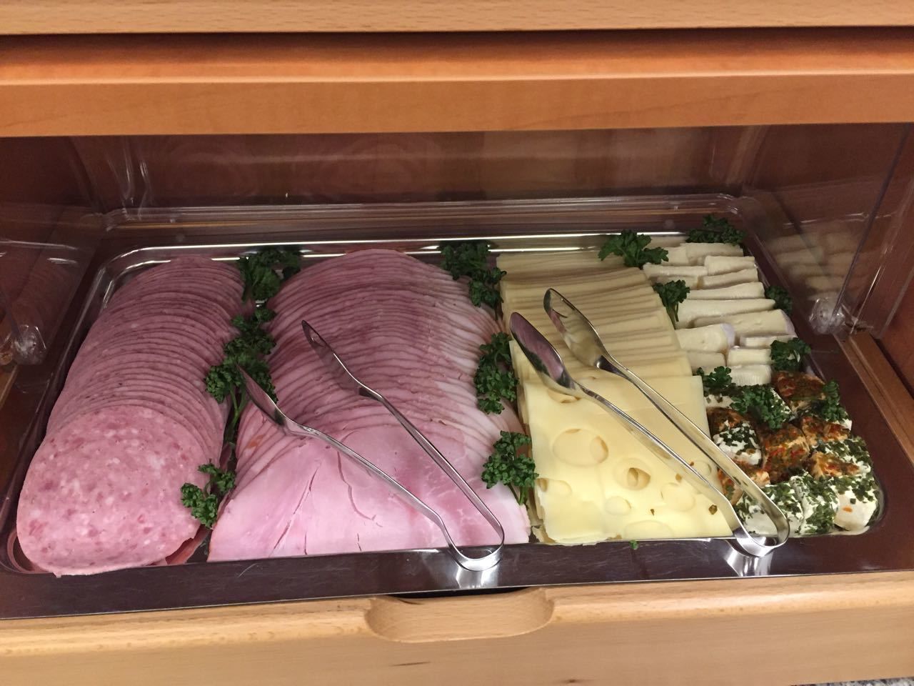 Noutopöytä, jossa on viipaloituja lihatuotteita, juustoja ja muita tarjoiluita.