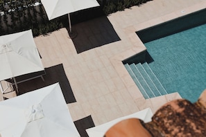 Una piscina al aire libre de temporada, sillones reclinables de piscina