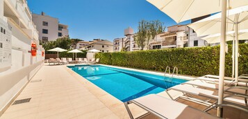 Una piscina al aire libre de temporada, sillones reclinables de piscina