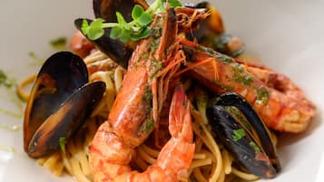 Une assiette de pâtes aux fruits de mer, avec des moules et des crevettes.