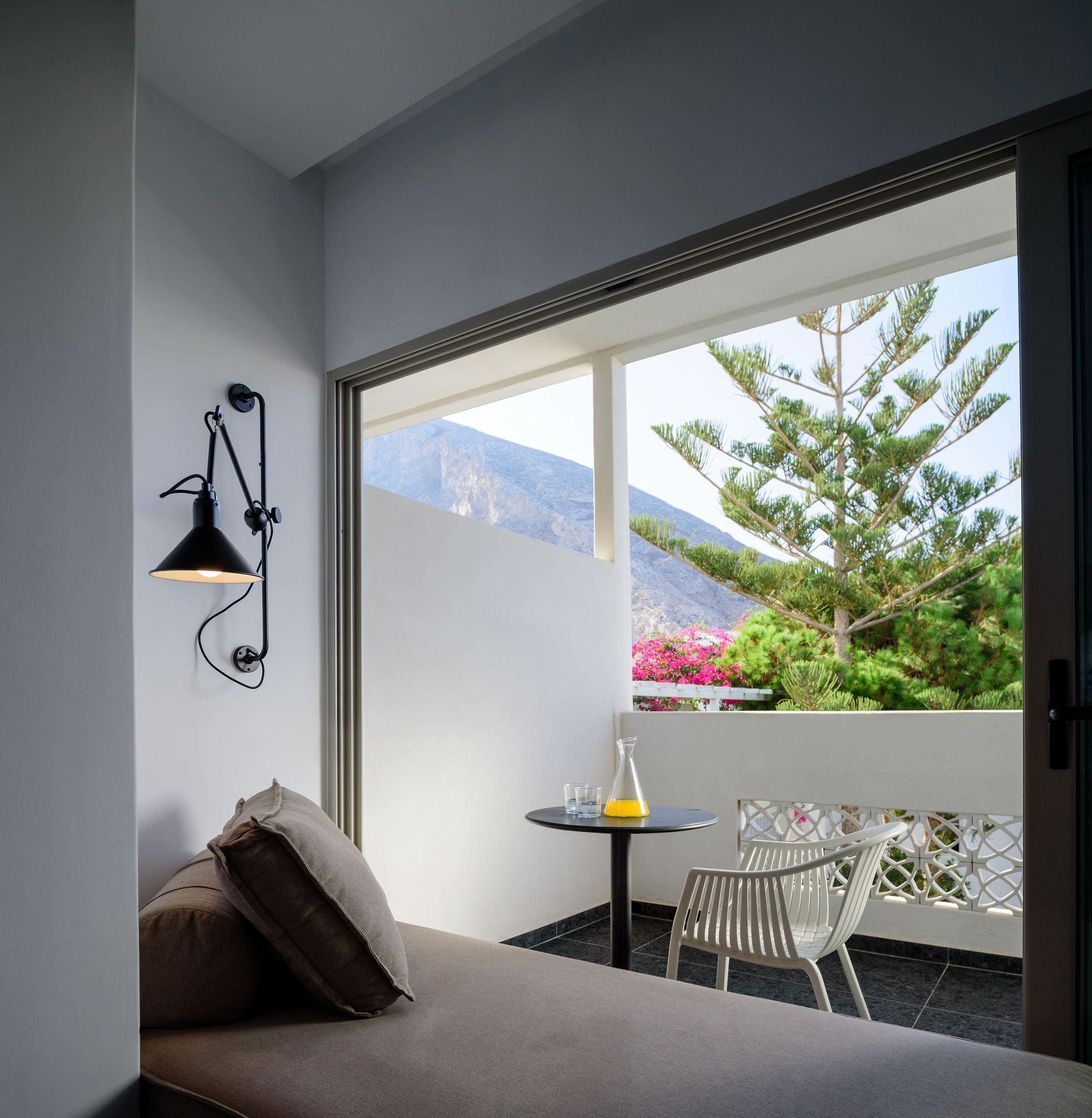 Un balcon avec un canapé, une petite table et une chaise.
