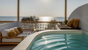Un espacio al aire libre con mobiliario y piscina, con vistas a un cuerpo de agua.