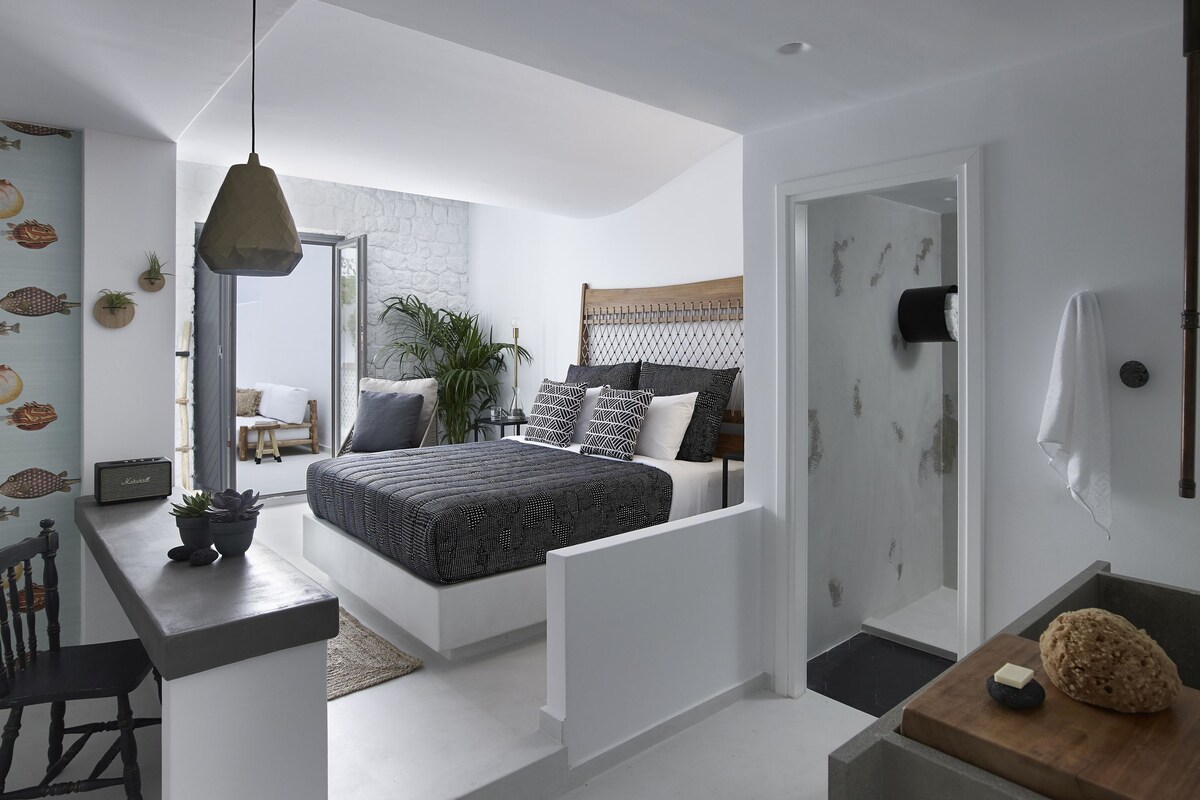 Un dormitorio moderno con cama, mesita de noche y vista al salón.