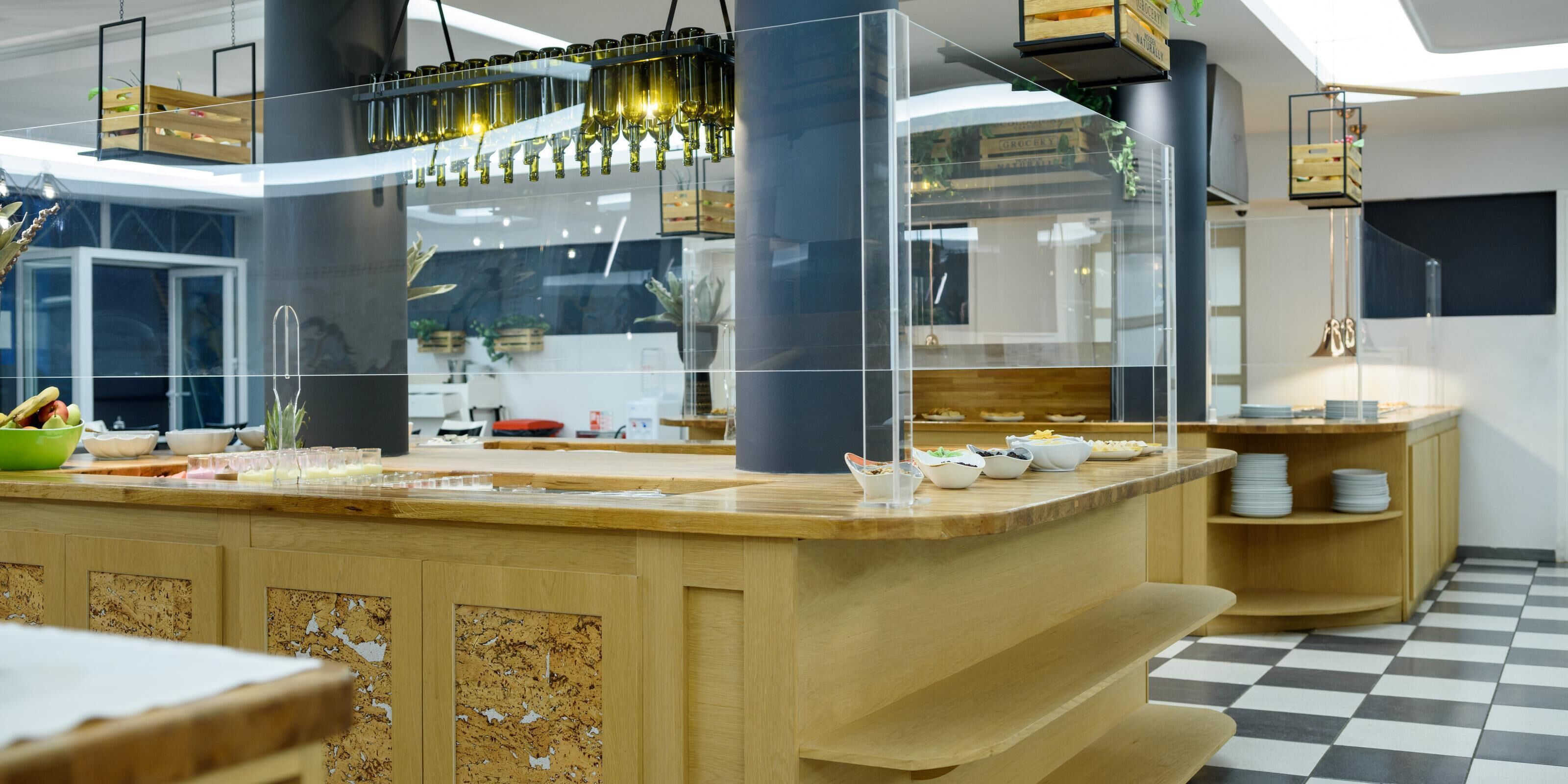 A modern kitchen with a central island, wooden cabinets, and a checkered floor.