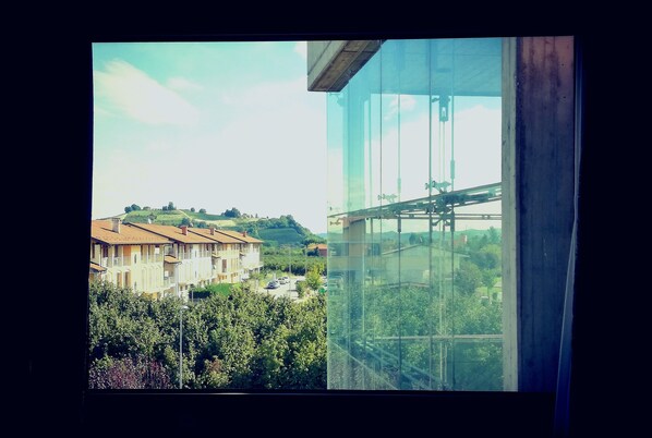 A view from a window overlooking a residential area with houses and greenery.