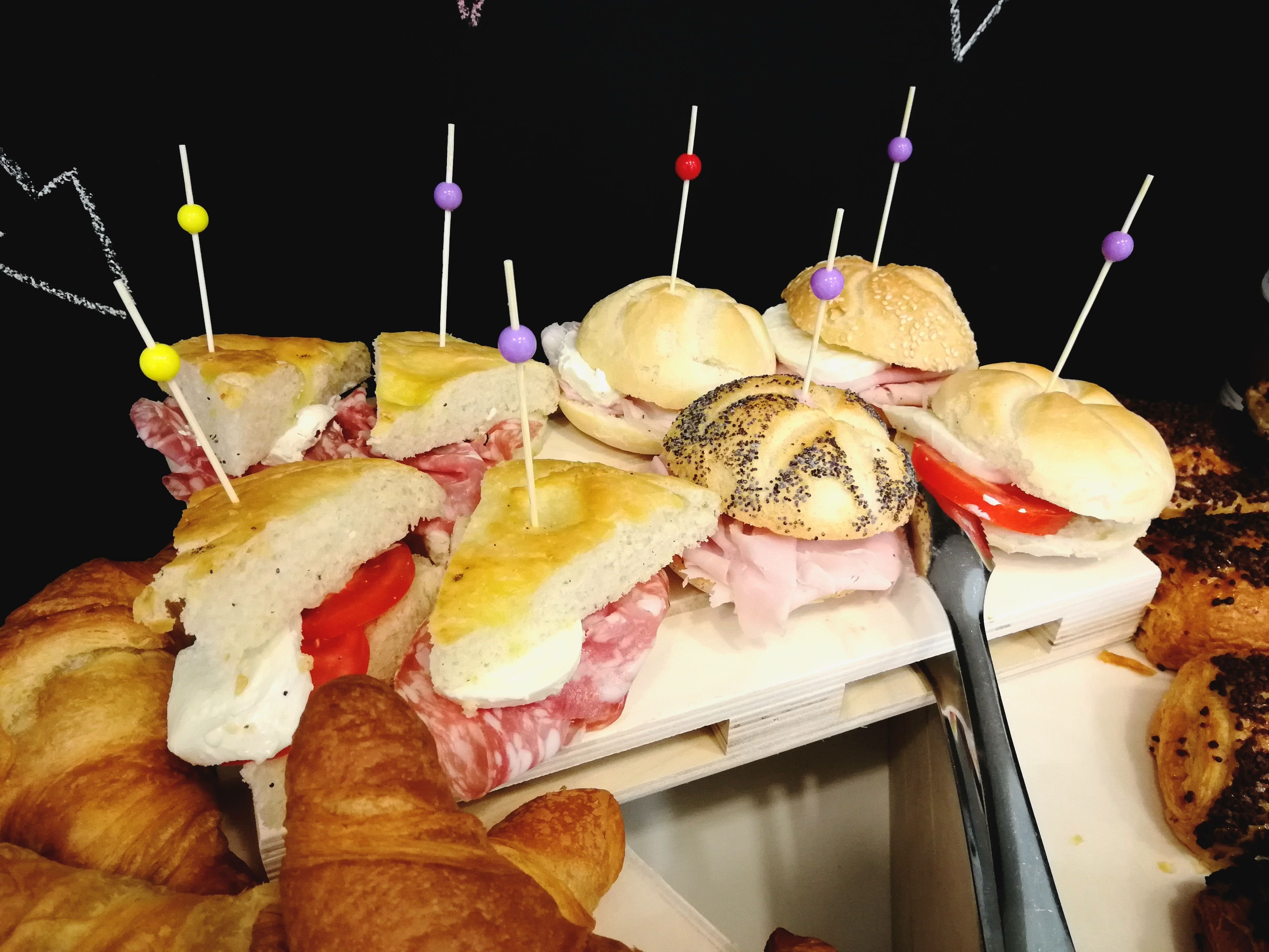 A variety of sandwiches and croissants on a tray.