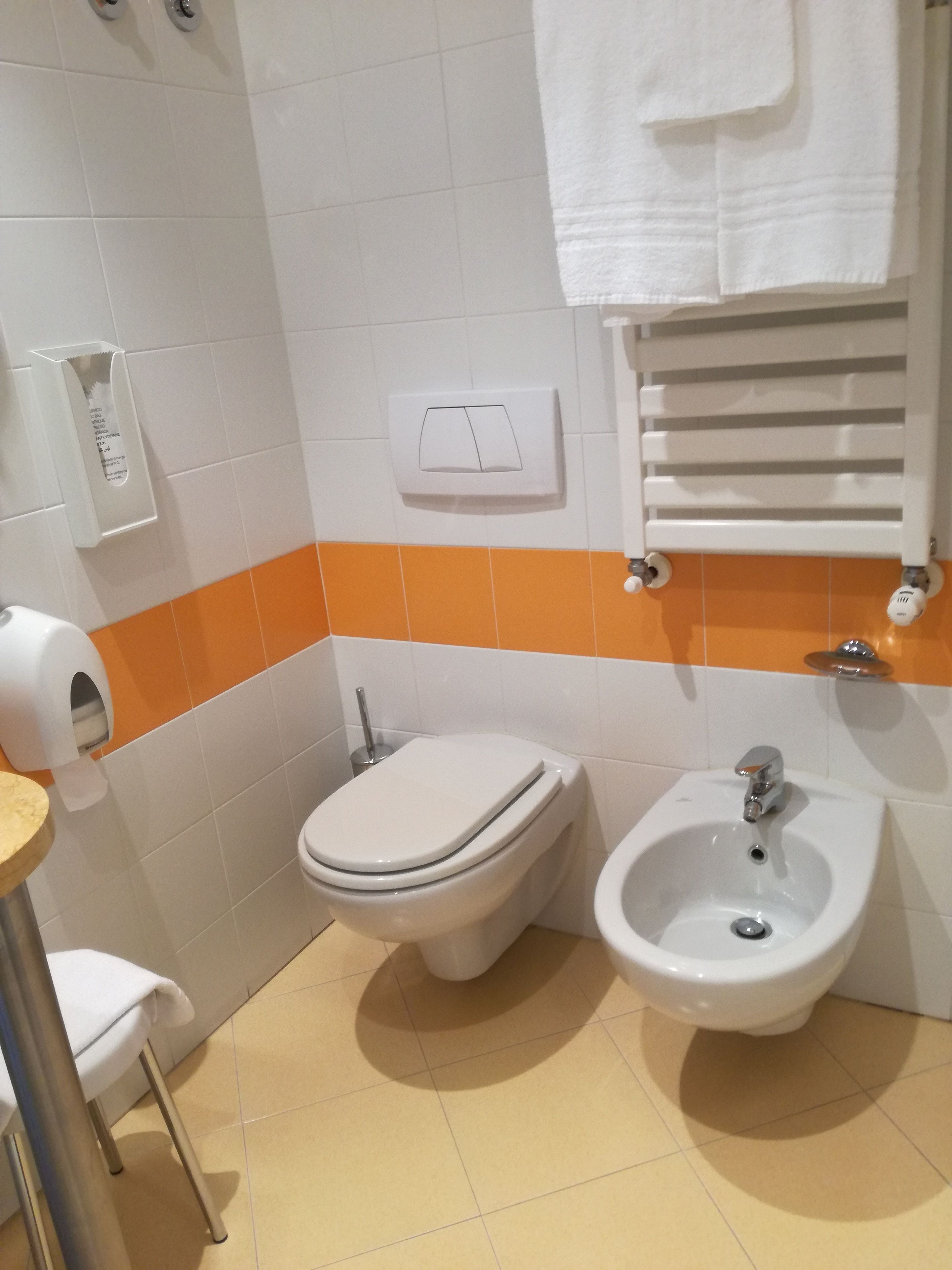 A bathroom with a toilet, bidet, and sink.