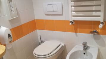 A bathroom with a toilet, bidet, and sink.