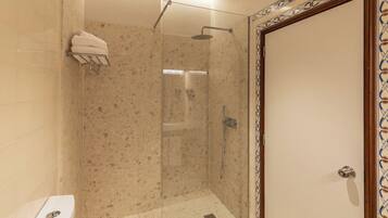 Un baño moderno con cabina de ducha de vidrio, inodoro y pared de azulejos.