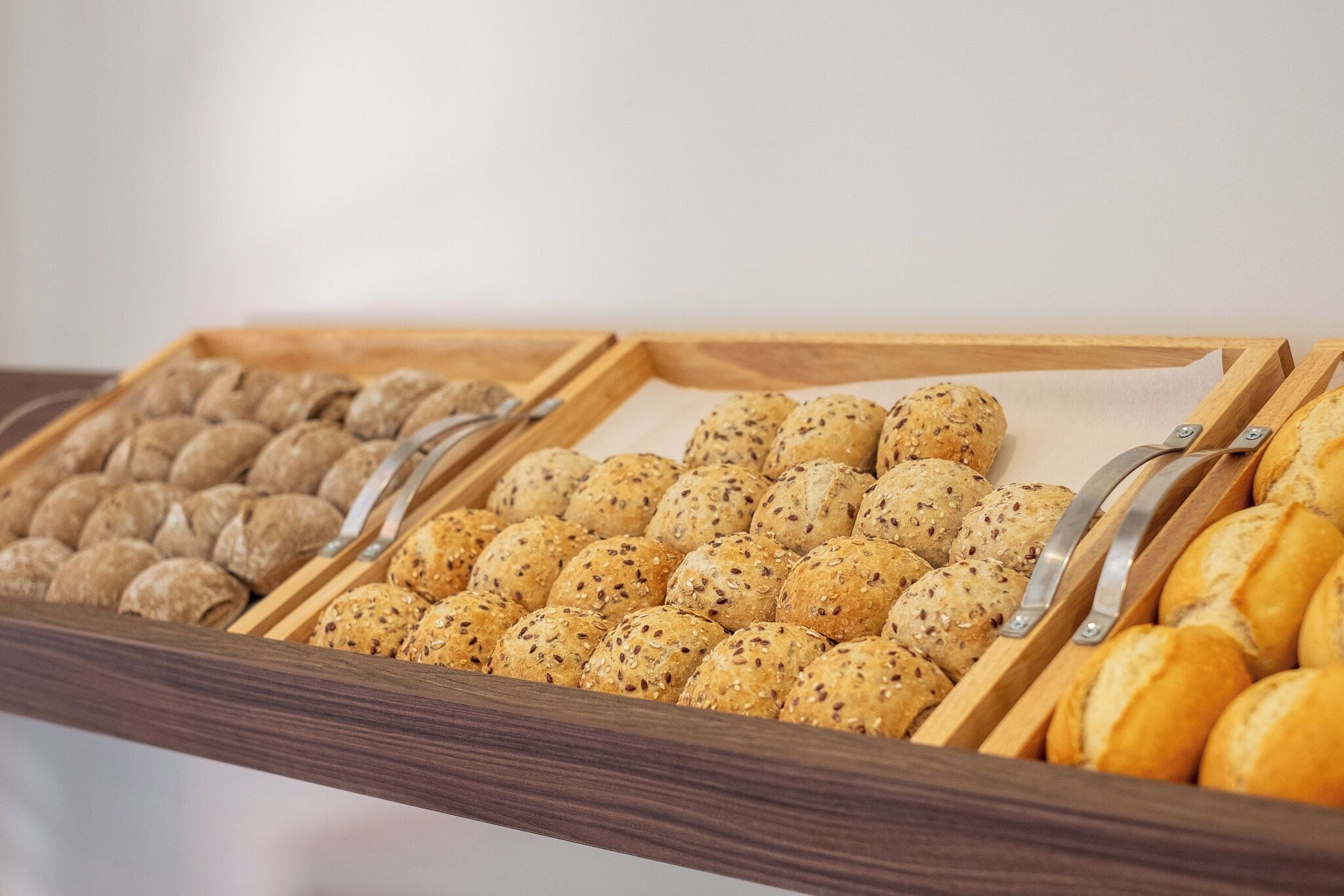 A buffet with various types of bread and pastries.