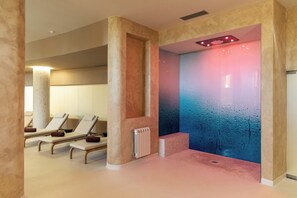 A spa area with massage chairs and a wall with a water feature.