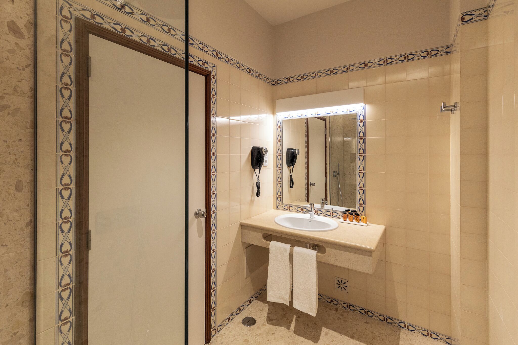 A bathroom with a sink, mirror, and hairdryer.