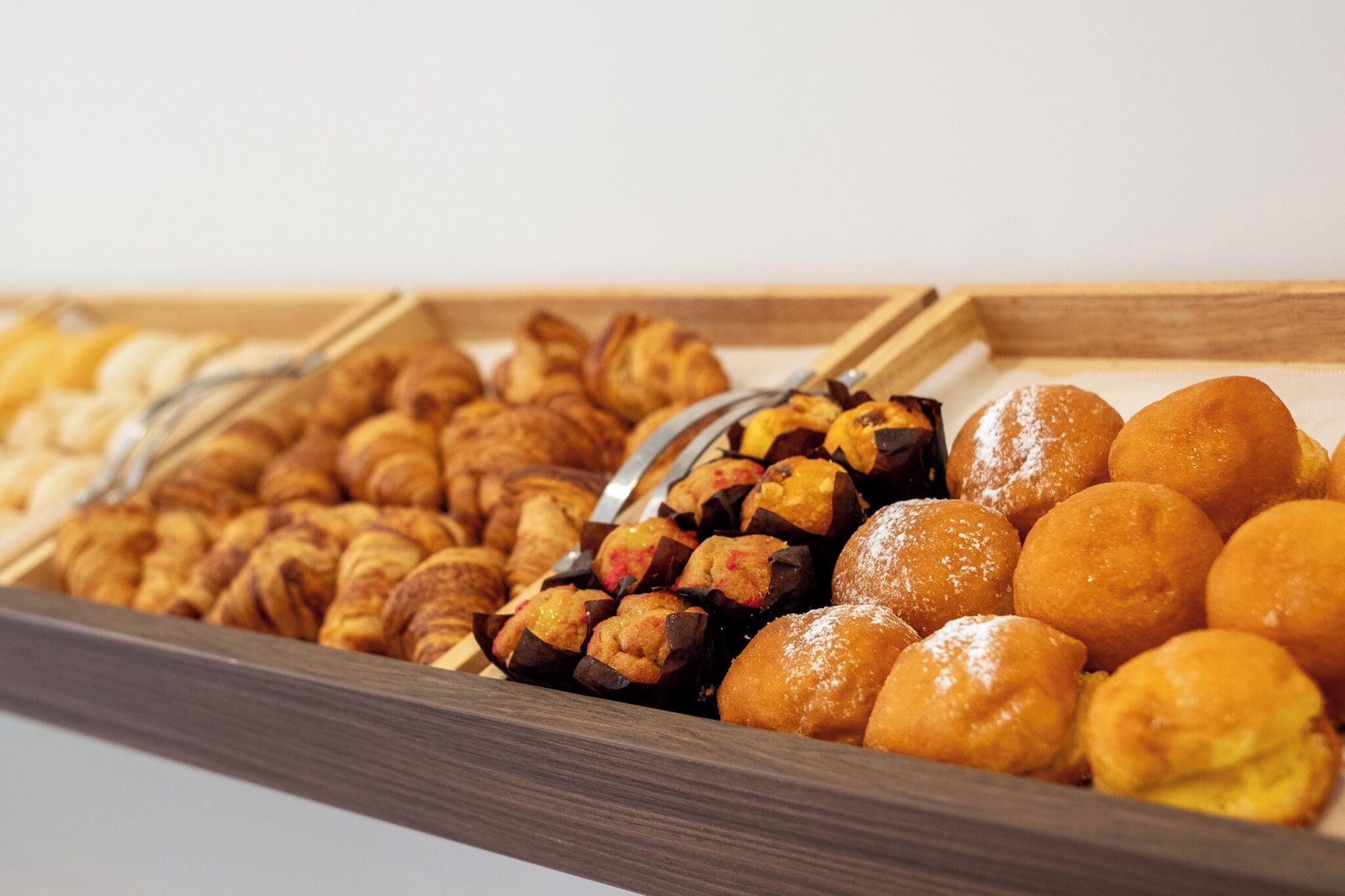 A variety of pastries displayed in a wooden tray.