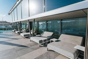 Een buitenzwembad, parasols bij het zwembad en ligstoelen