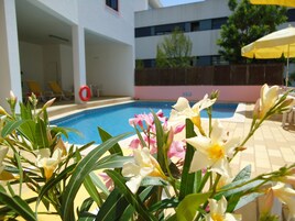 Una piscina al aire libre de temporada, sillones reclinables de piscina