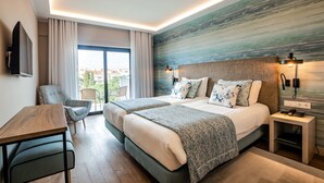 A modern hotel room with two beds, a desk, a chair, and a view of the outdoors. - Marina Rio (Lagos)
