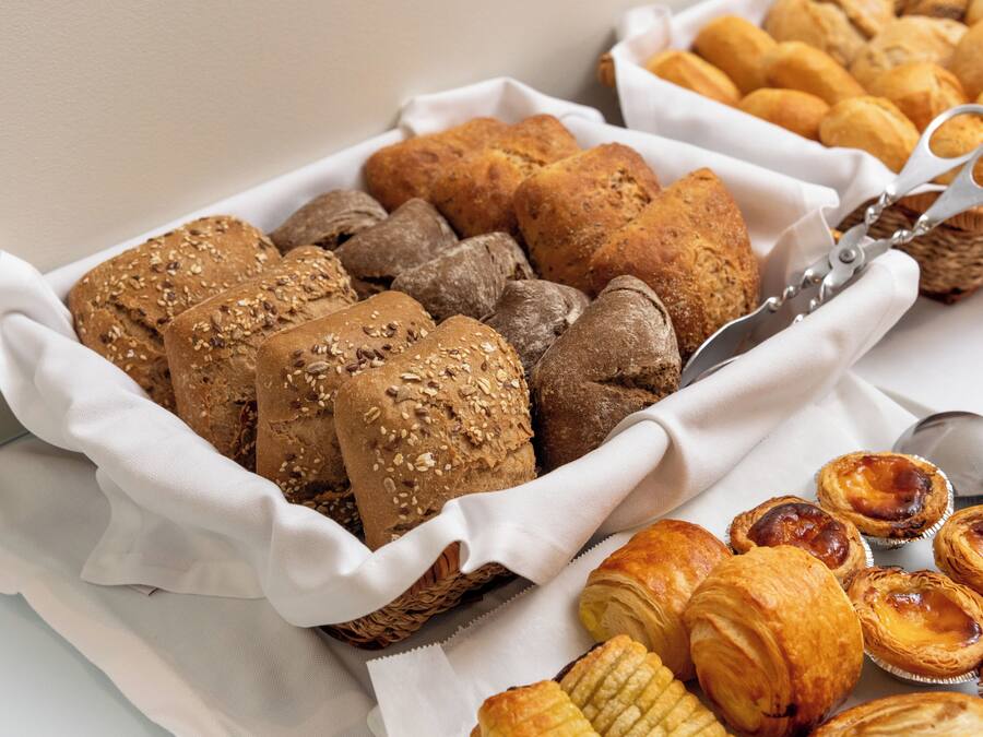 A variety of baked goods including bread, rolls, and pastries arranged on a table.