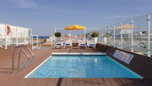 A pool area with a clear view of the sea, a lifebuoy, and a signboard. - Marina Rio (Lagos)