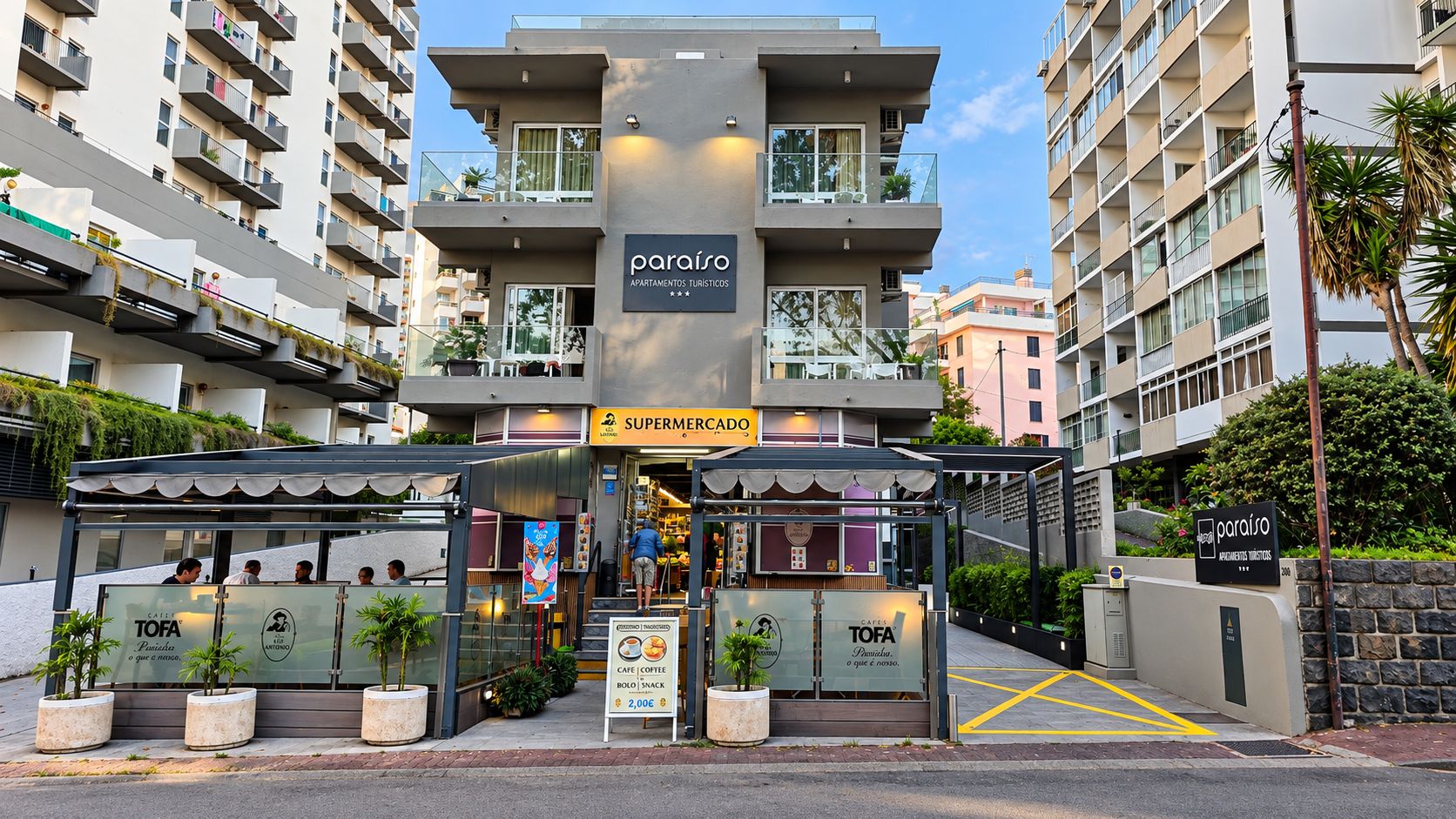 Un edificio moderno con un letrero para los apartamentos 'paraíso' y la entrada a un 'SUPERMERCADO'.