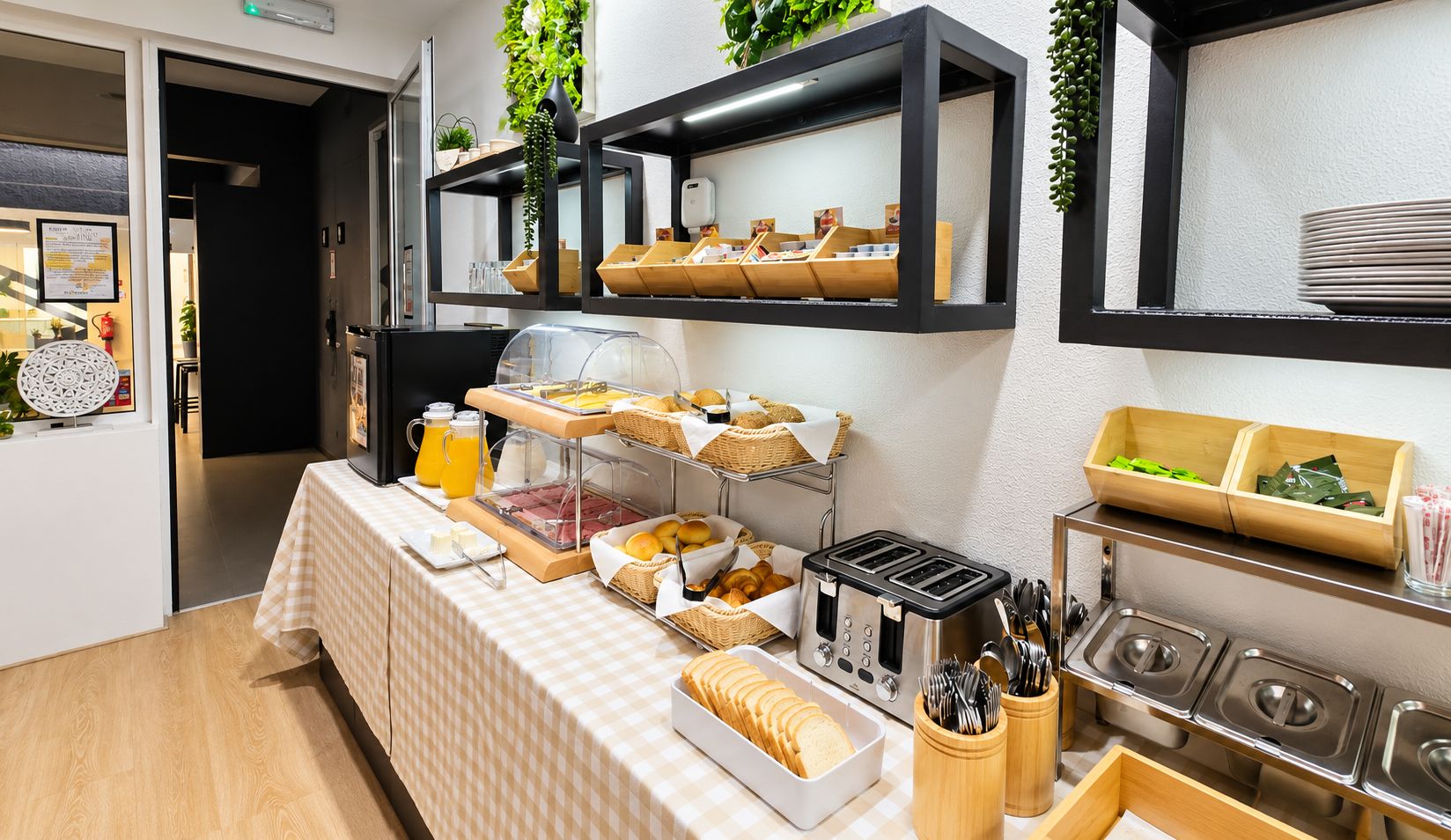 Montaje de bufé con diversos alimentos, un tostador y utensilios.